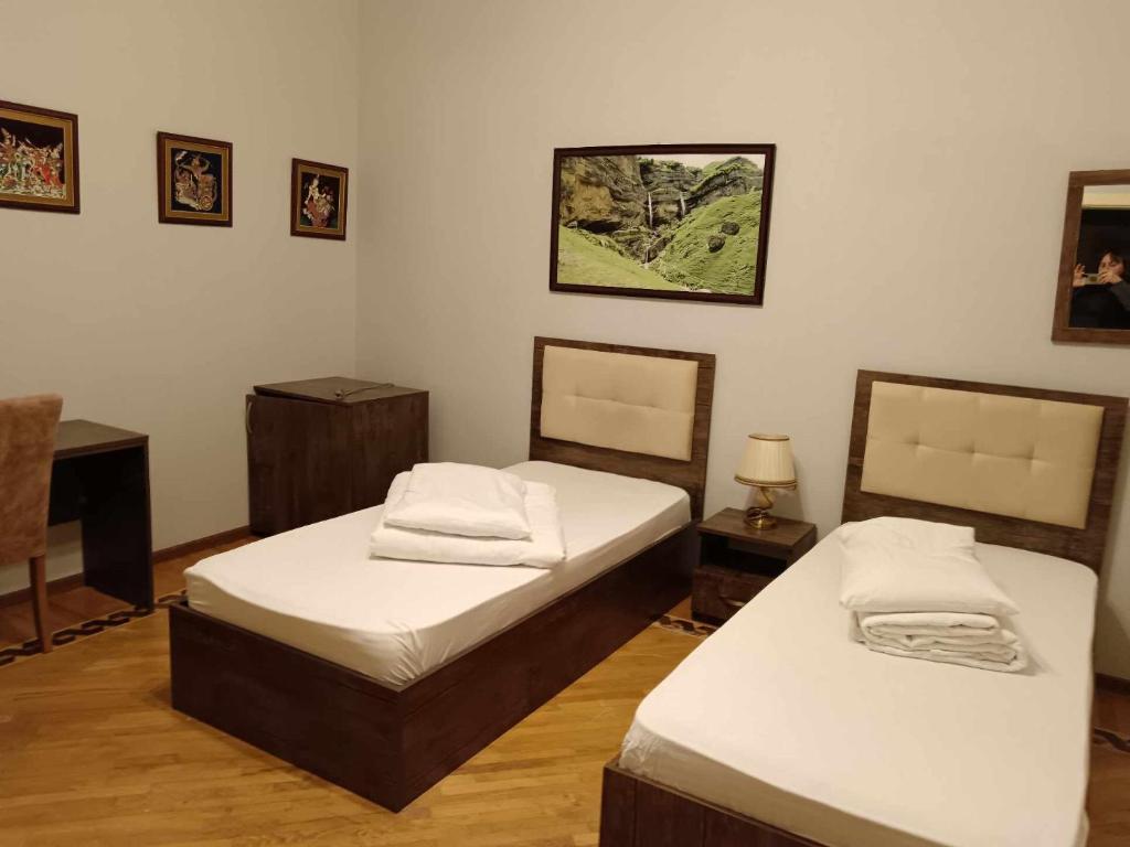 a bedroom with two beds and a desk and a piano at soprano guest house in Baku