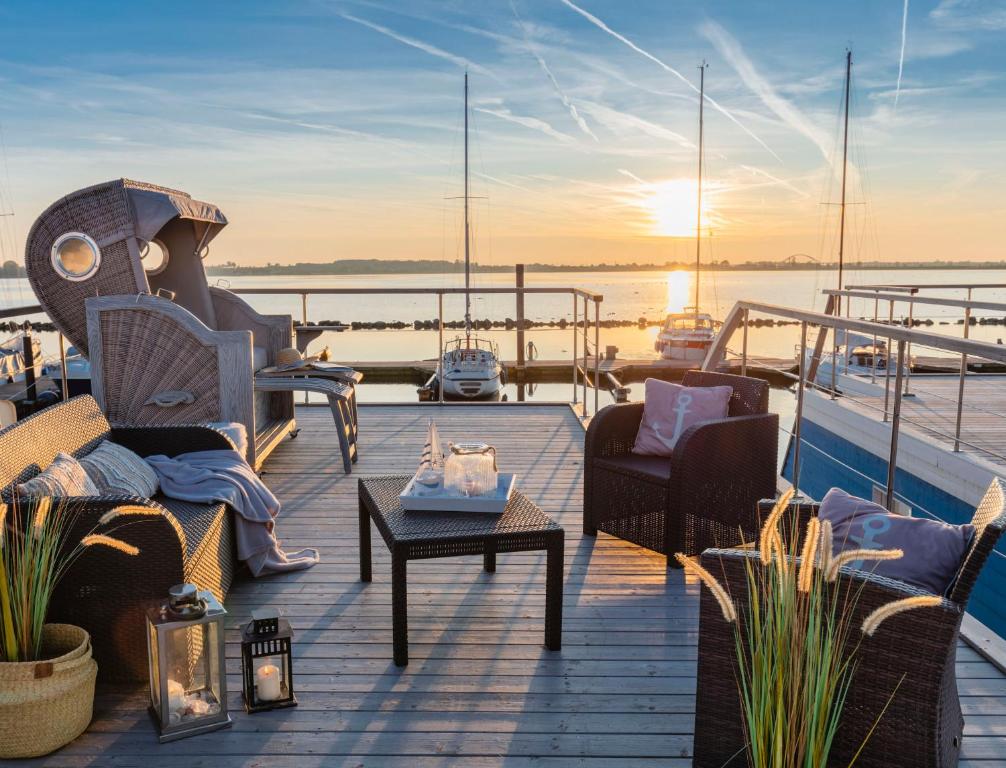 una terraza con sillas y mesas en un barco en Hausboot The Goose, en Burgstaaken