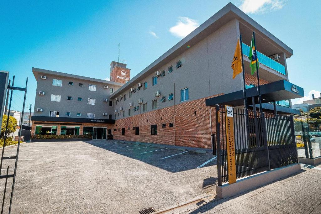 a large building with flags in front of it at Hotel Werlich in São José