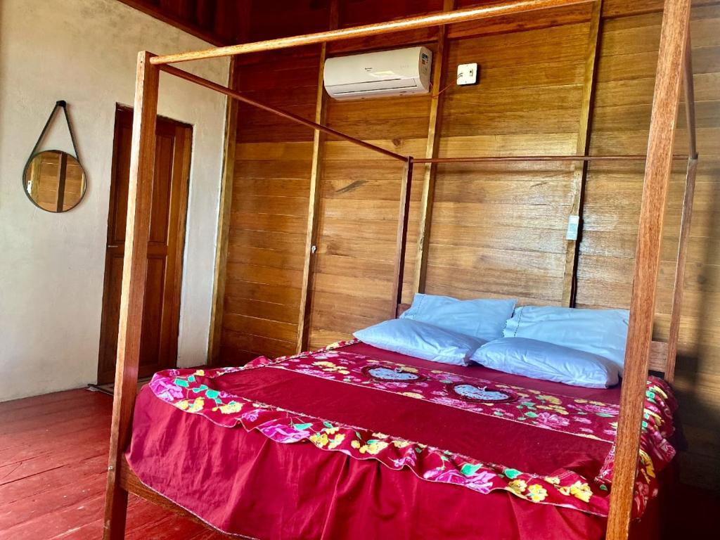 Cama en habitación con pared de madera en LUZ AMAZÔNIA LODGE, en Iranduba