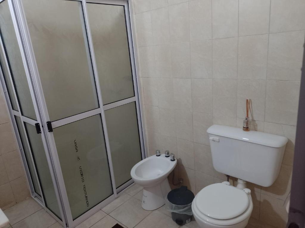 a bathroom with a toilet and a glass shower at La Armonía in Chilecito