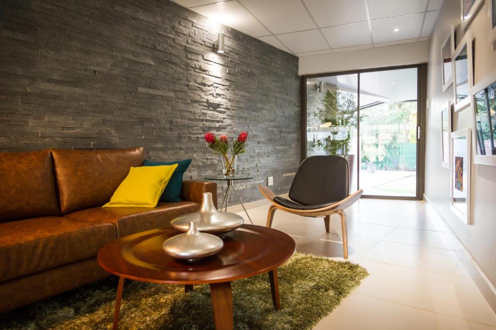 a living room with a couch and a table at Palm Lodge Guest House in Bloemfontein