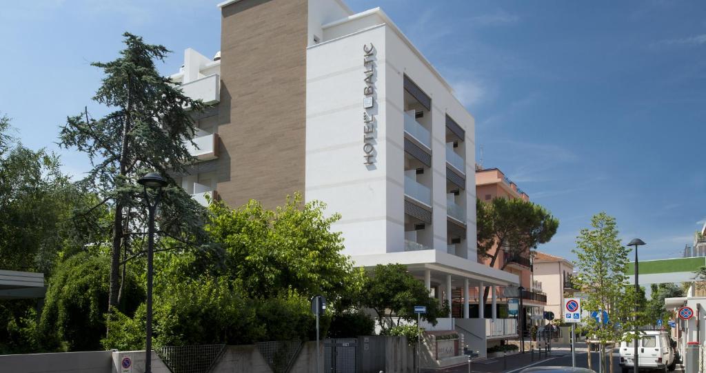 a white building with a sign on the side of it at Hotel Baltic in Rimini