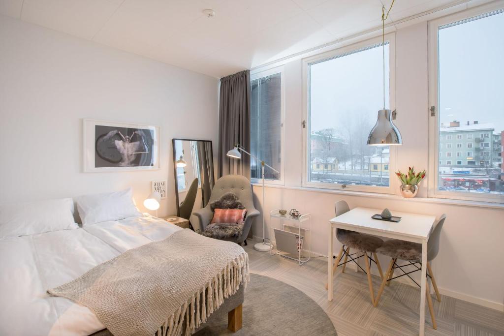 1 dormitorio con 1 cama, escritorio y 2 ventanas en Studios - Södertälje, en Södertälje