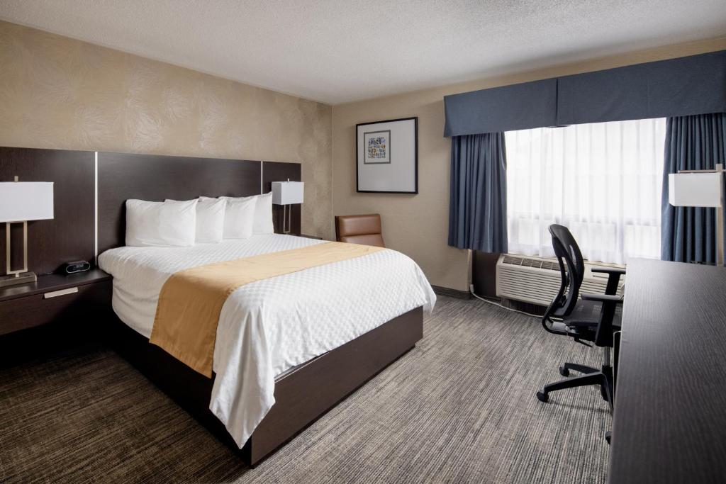 a hotel room with a bed and a desk at Stonecroft Inn in Windsor