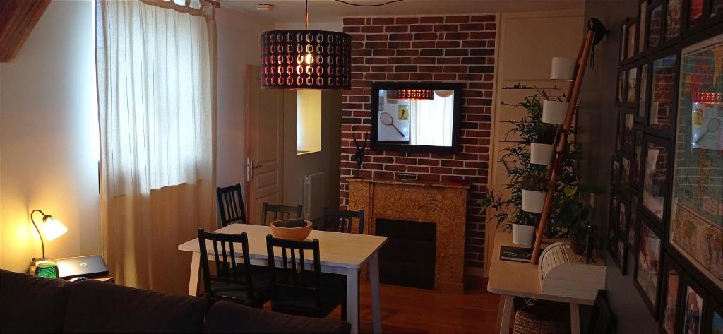 un salon avec une table et une cheminée dans l'établissement Appartement Centre ville + parking, à Orléans