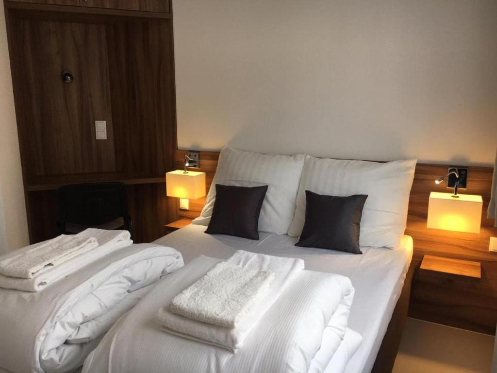 duże białe łóżko z dwoma ręcznikami w obiekcie Apartments DeLuxe Center NOWY ŚWIAT w mieście Białystok