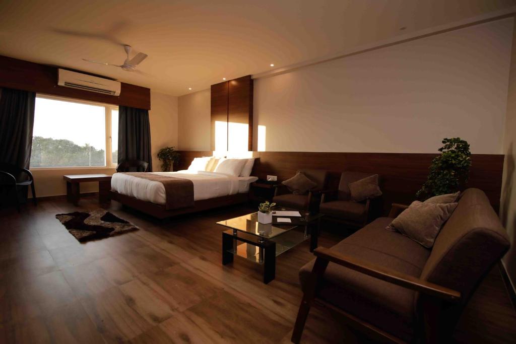 迪布鲁加尔Hotel Tree Fern的配有床和沙发的酒店房间