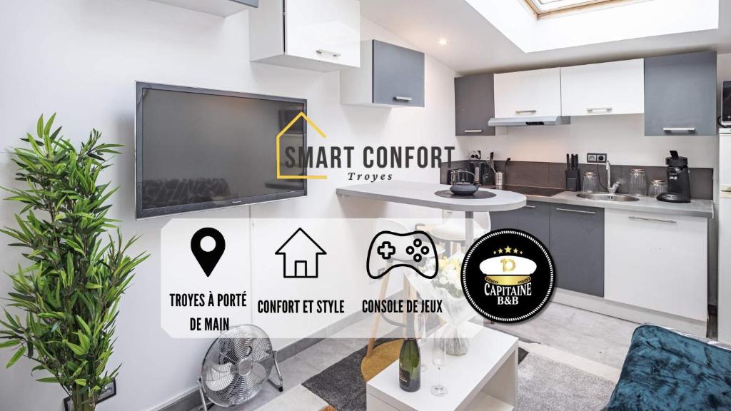 Il comprend une cuisine avec des placards blancs et une télévision murale. dans l'établissement Smart Confort 17 - Appartement confort et stylé, à Troyes