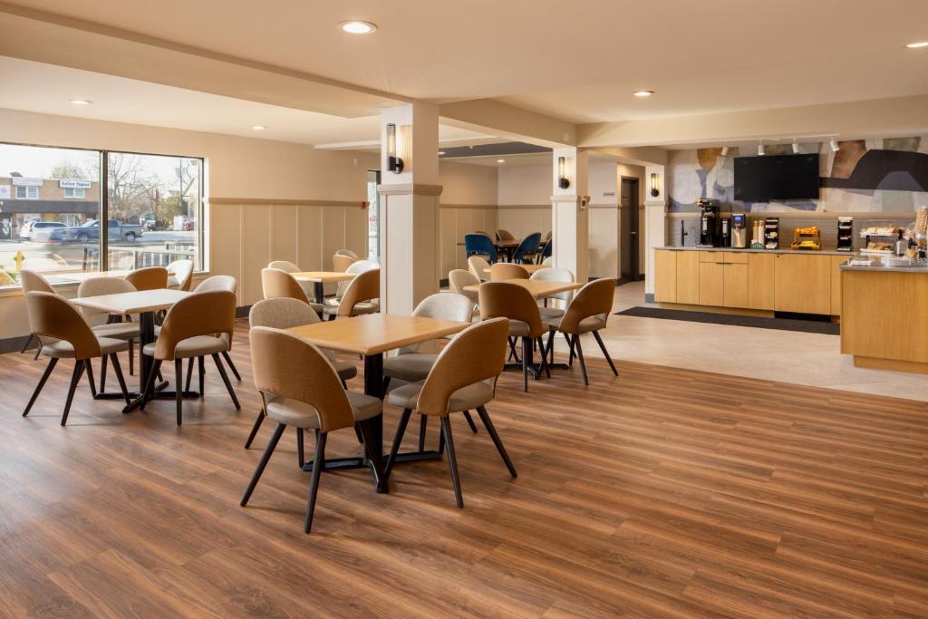 a restaurant with tables and chairs and a kitchen at Stonecroft Inn in Windsor