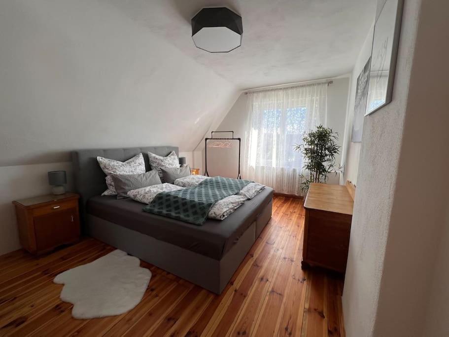 a bedroom with a bed and a wooden floor at Kleine Auszeit im Seenland in Hohenbocka
