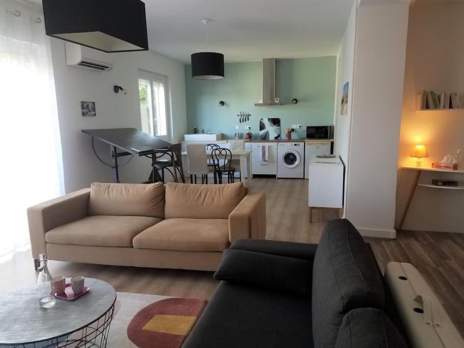 uma sala de estar com um sofá e uma cozinha em Loft ravissant proche du centre-ville em Nîmes