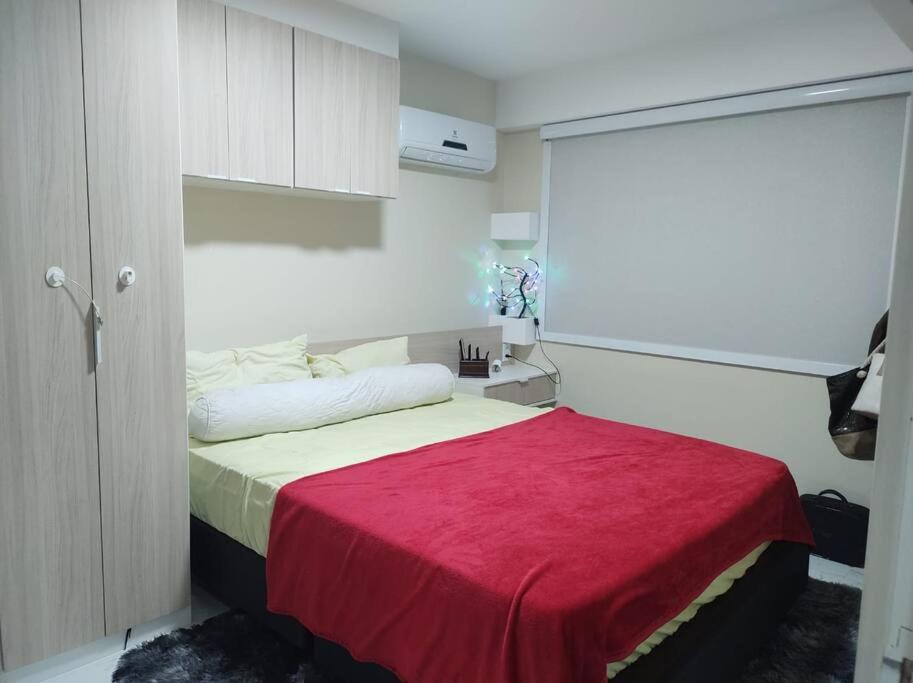 Un dormitorio con una cama con una manta roja. en Paraíso frente ao mar, en Río de Janeiro
