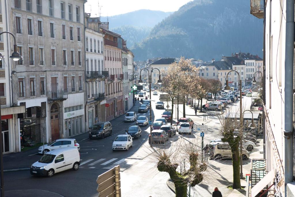 a busy city street with cars parked on the road at Kasa Jura 2 - Centre ville - Proche pistes de ski in Saint-Claude