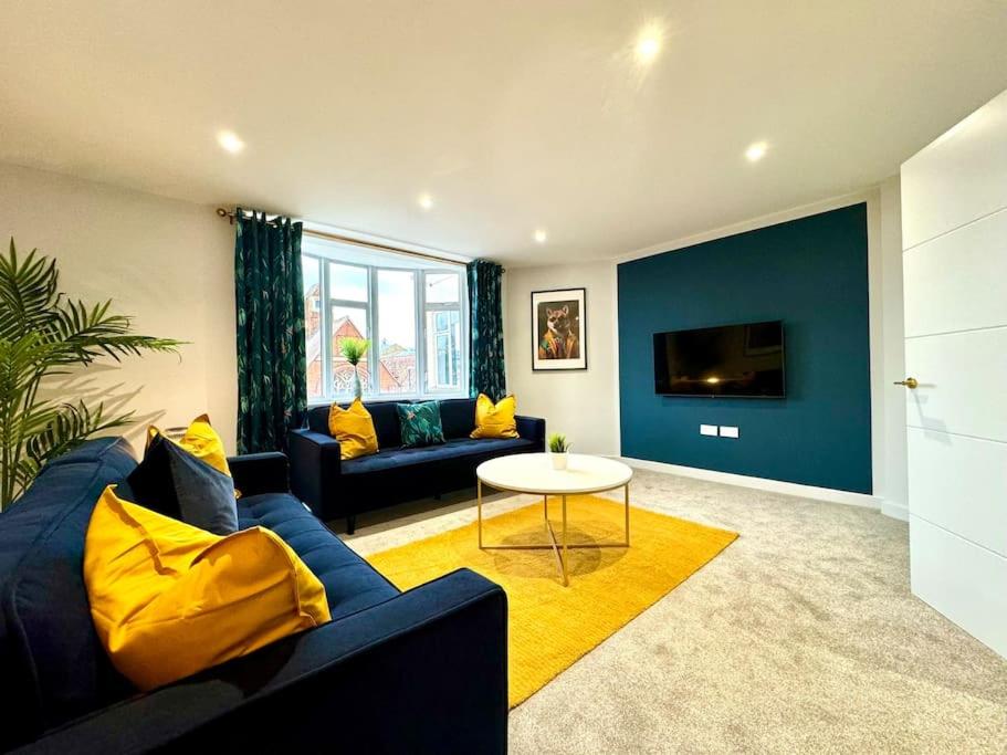 sala de estar con sofá azul y mesa en Coastal 3BR Bournemouth Apartment, Prime Location, en Bournemouth