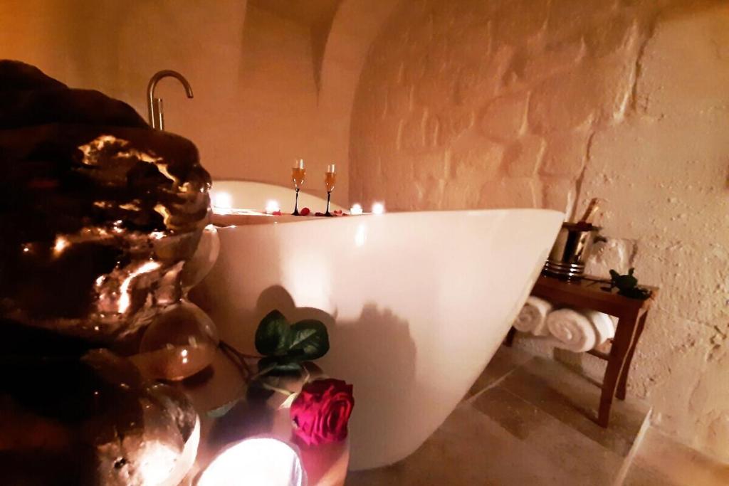 La salle de bains est pourvue d'une baignoire blanche et de bougies. dans l'établissement Guernica Apartment Paris Montmartre, à Paris
