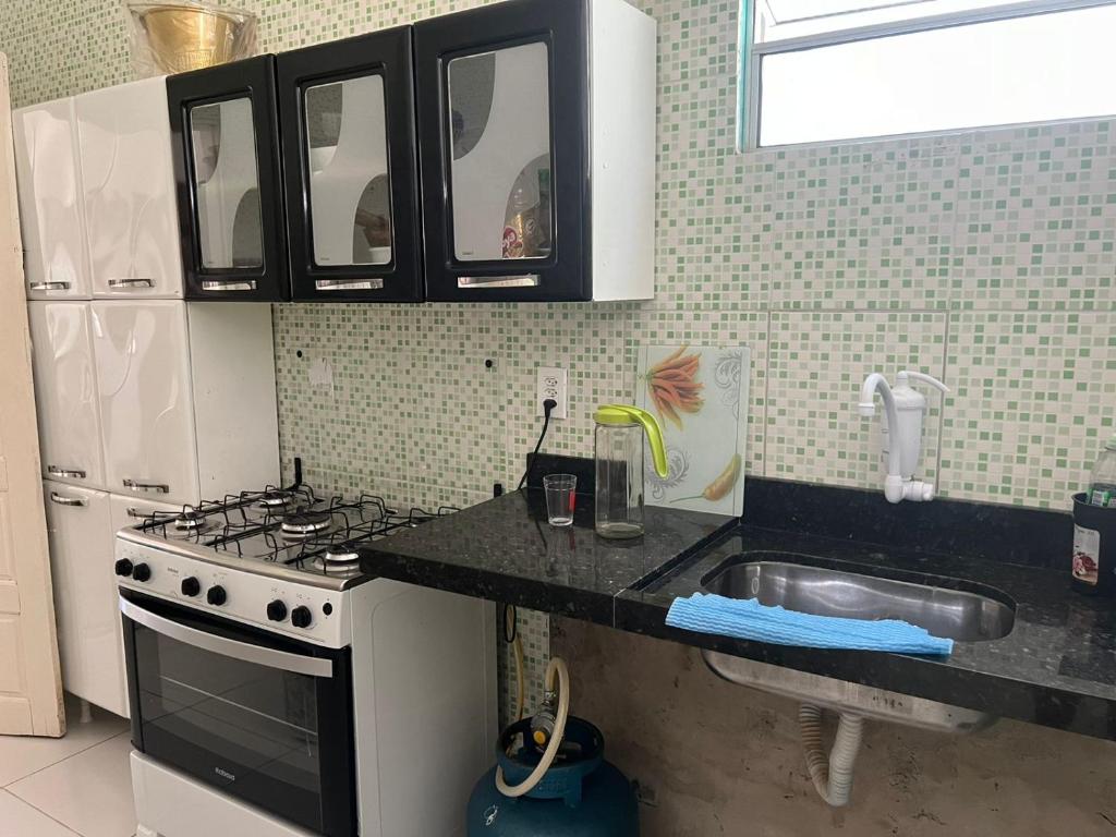 a kitchen with a stove and a sink at Casa do Sossego in Guaibim