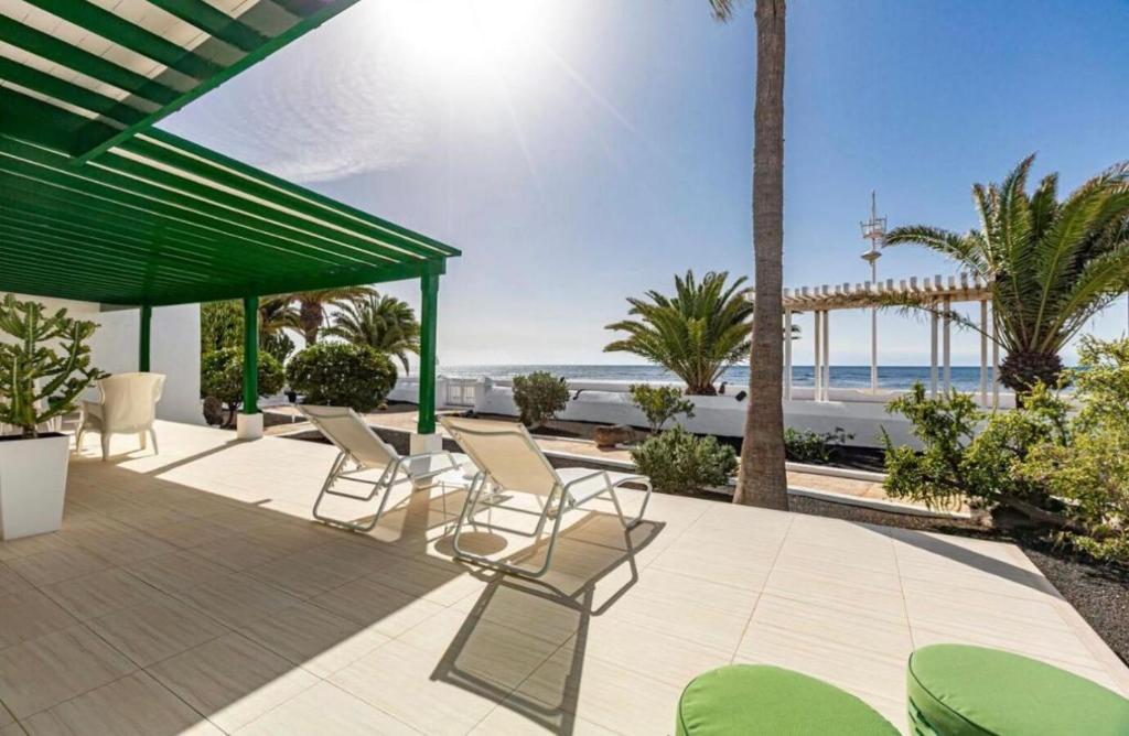 patio z krzesłami i widokiem na plażę w obiekcie Luxury Villa Sea Front -La Orilla w mieście Playa Honda