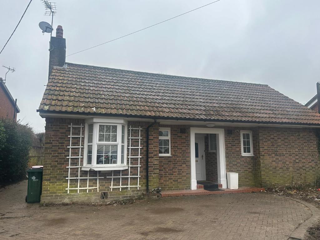 een klein bakstenen huis met een wit raam bij Cosy Cottage in Crawley