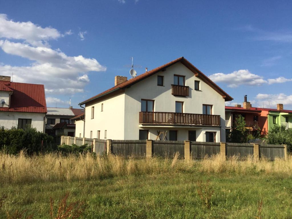 a white house with a fence in a field at Pension 325 in Tábor
