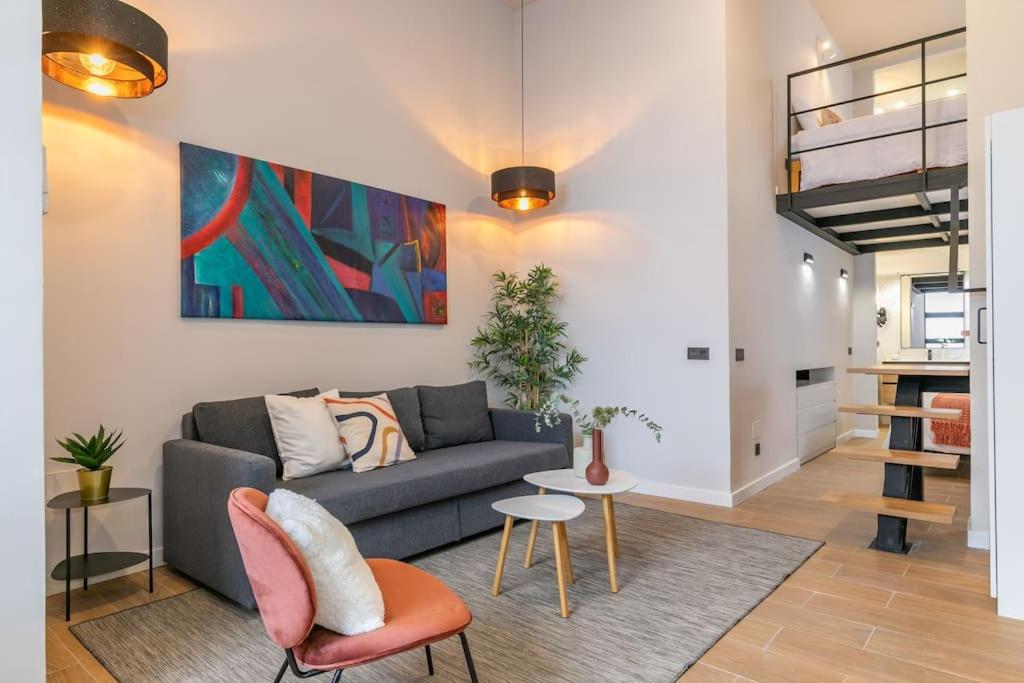 a living room with a couch and a painting on the wall at Beautiful duplex in front of Vista Alegre Palace in Madrid
