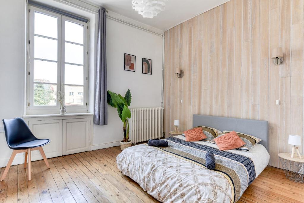 une chambre avec un lit, une chaise et une fenêtre dans l'établissement Le Marty - wifi - central - climatison - parking gratuit, à Carcassonne