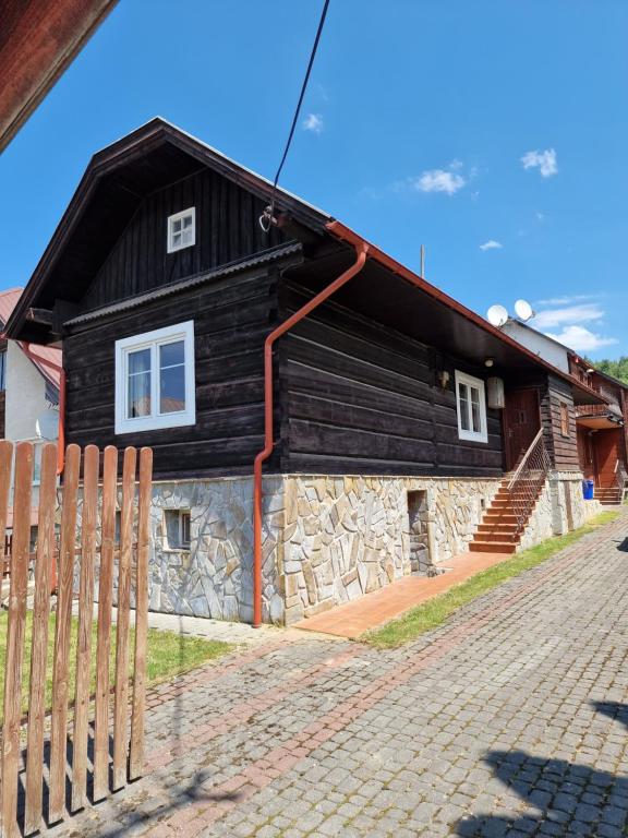 a wooden house with a fence in front of it at Drevenica Vitanová in Vitanová