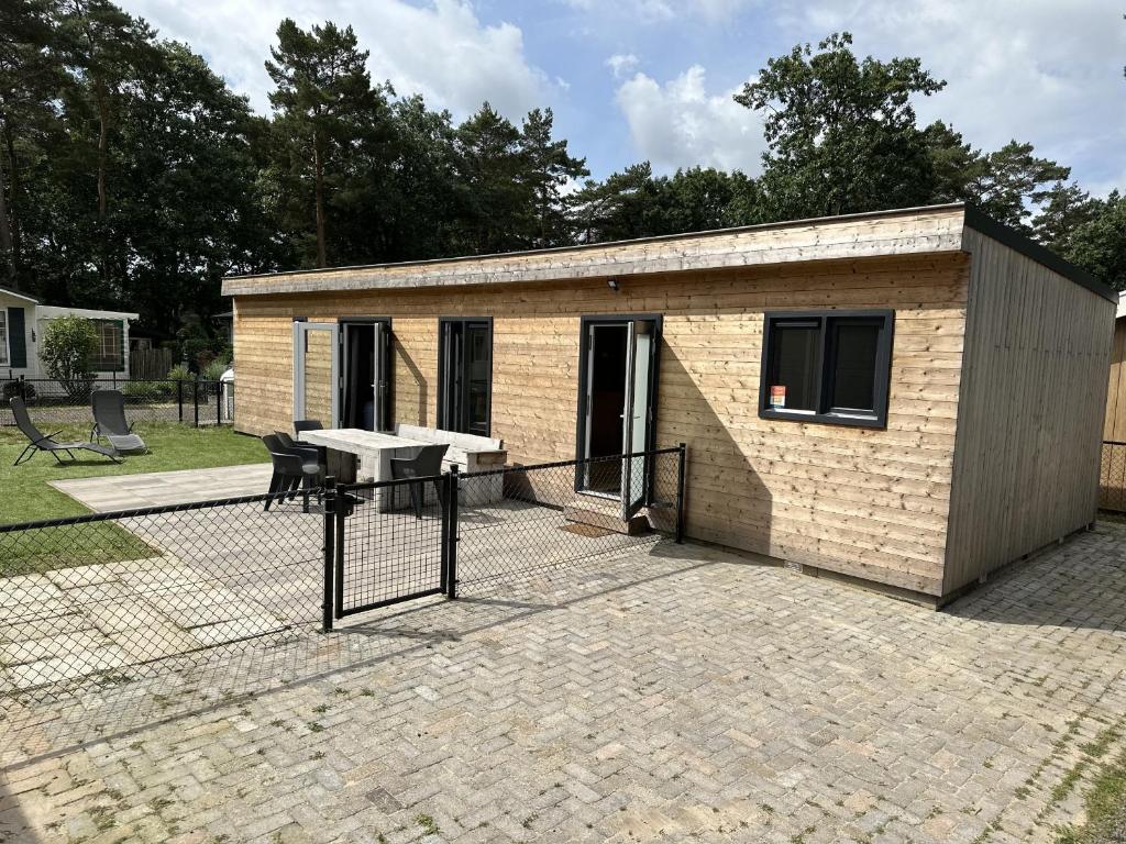 un pequeño edificio con una mesa de picnic en un patio de ladrillo en Bospark Wolfsven - BPW 1110 en Mierlo