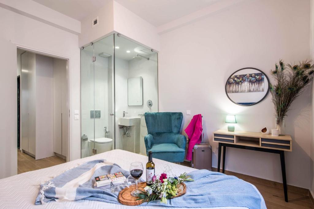 a hotel room with a bed and a blue chair at Elegant, Spacious and hitech apt at Koukaki in Athens