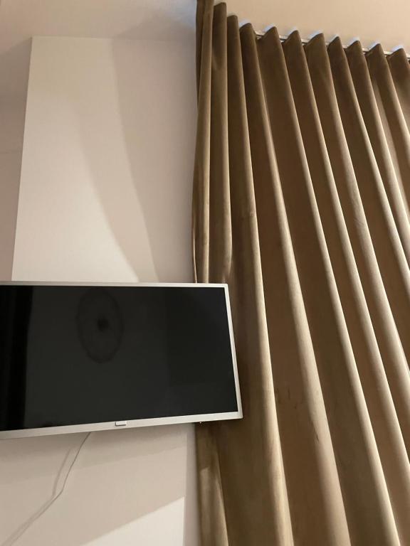 telewizor z płaskim ekranem siedzący obok zasłony w obiekcie Wip Appartament Solec rezidencia w Warszawie