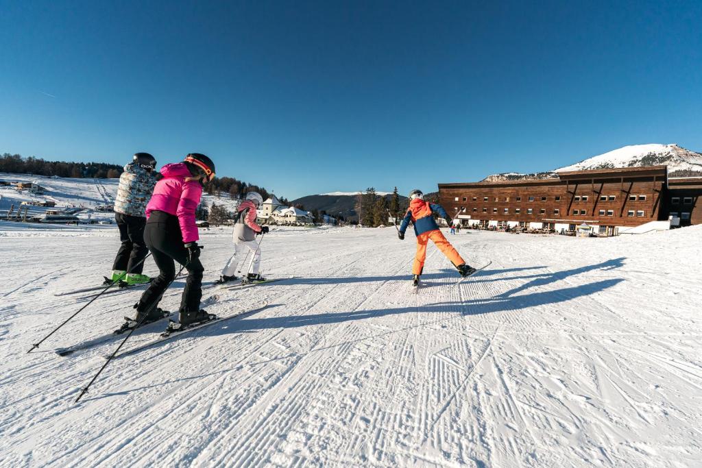 a group of people on skis in the snow at Monte Pana Dolomites Hotel in Santa Cristina Gherdëina