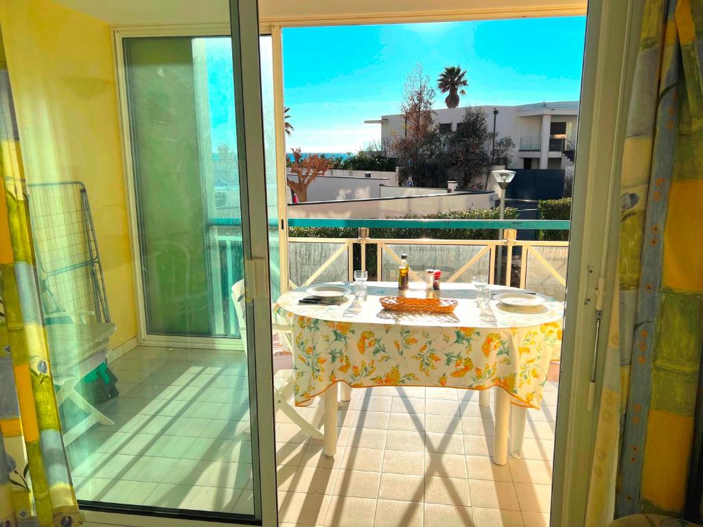 - un balcon avec une table et un gâteau dans l'établissement SAVANNA BEACH II Joli appartement 3 pièces avec piscine Rochelongue Cap d'Agde, au Cap d'Agde