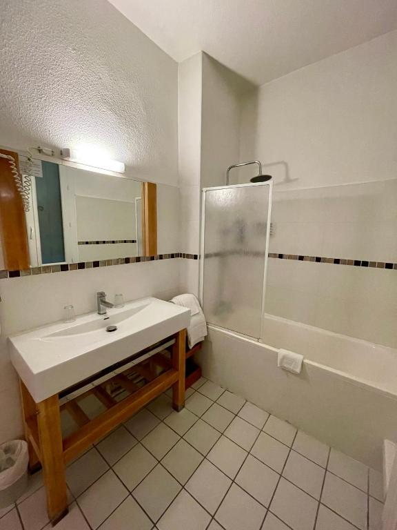 a bathroom with a sink and a shower at Hôtel Colisée-Verdun Centre Gare Saint-Roch in Montpellier
