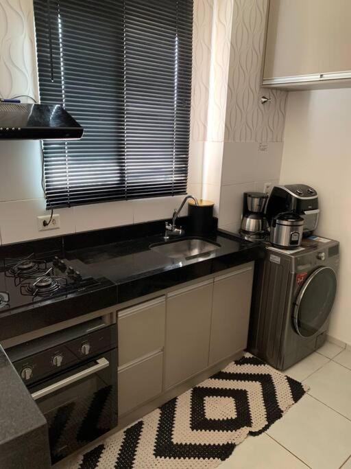 cocina con fregadero y lavadora en Um apartamento bem aconchegante! en Palmas