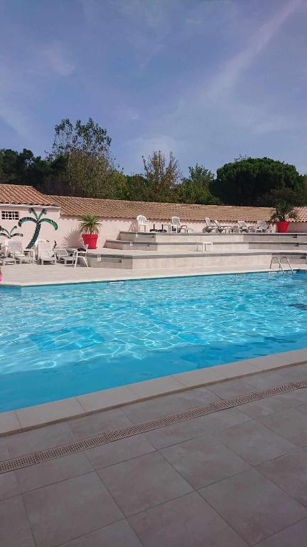 une grande piscine avec de l'eau bleue et des chaises dans l'établissement App le palais d'été, à Argelès-sur-Mer