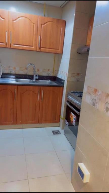 a kitchen with wooden cabinets and a sink and a stove at عجمان in Ajman 