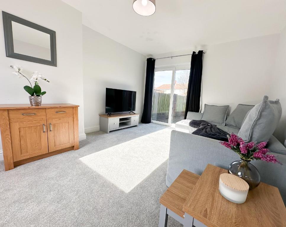 a living room with a couch and a tv at York House by Blue Skies Stays in Stockton-on-Tees