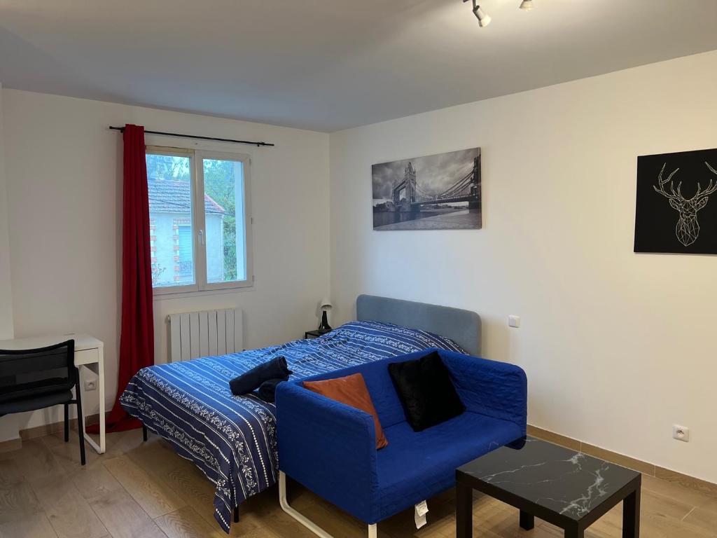 sypialnia z łóżkiem i niebieskim krzesłem w obiekcie Studio lumineux w mieście Saint-Denis