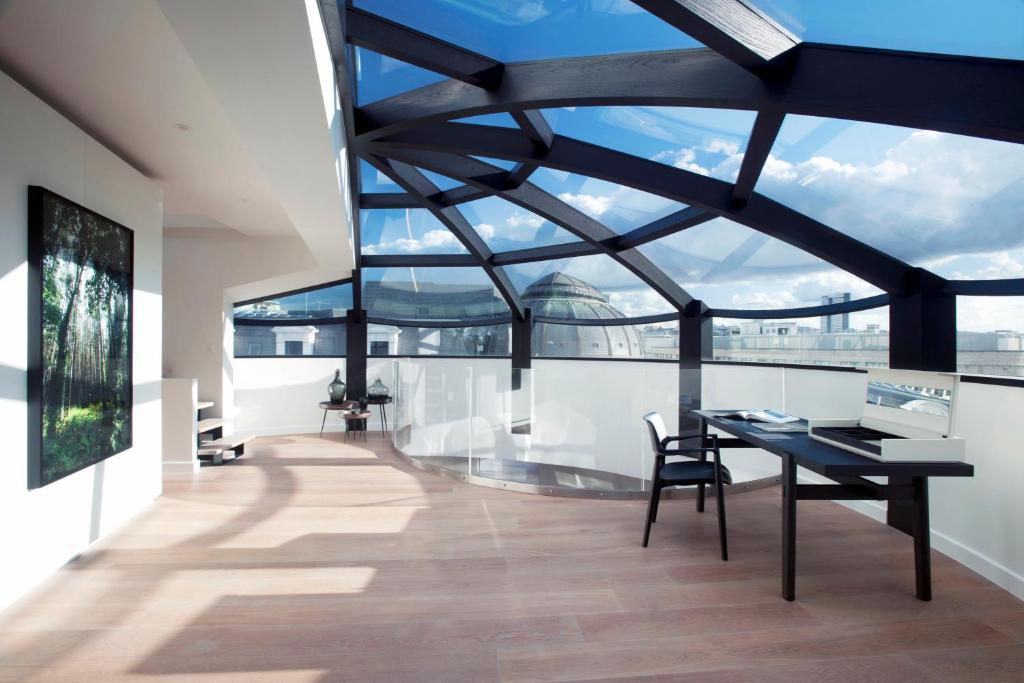 een kamer met een tafel en stoelen en een groot raam bij Triplex penthouse in the city center in Brussel