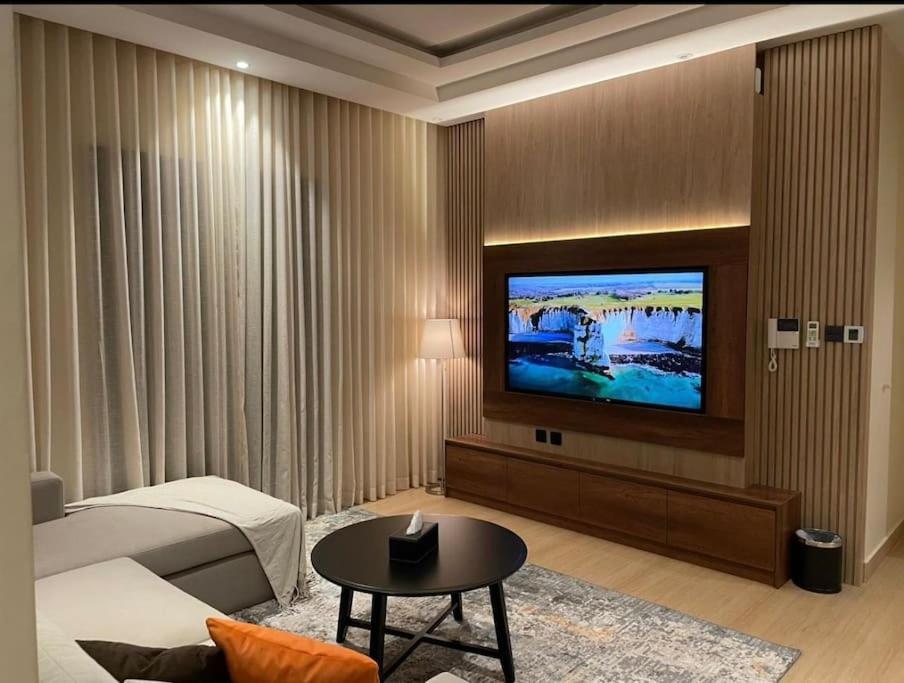 a hotel room with a bed and a flat screen tv at وحدة الملقا لاقزجري in Riyadh