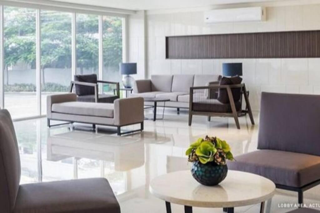 una sala de estar con sofás y un jarrón sobre una mesa en A's Staycation -Trees Residences, en Manila