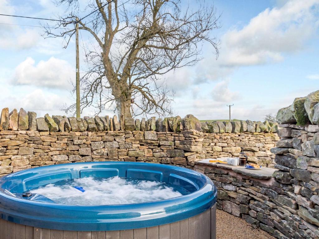 a hot tub in front of a stone wall at 2 Bed in Allendale 78158 in Catton