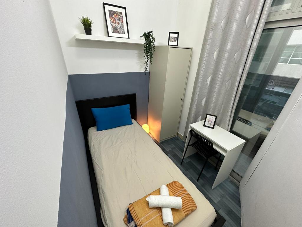een kleine slaapkamer met een bed en een tafel bij Partition Room 5 Mins to Mashreq Metro in Dubai