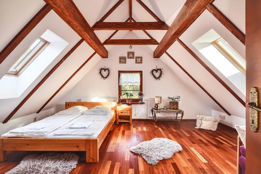 a attic bedroom with a bed and wooden floors at Willa nad Popradem in Piwniczna-Zdrój