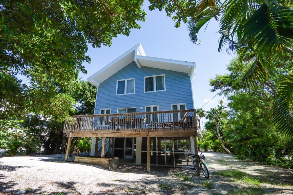 une maison bleue avec une terrasse sur une plage dans l'établissement Beautifully Updated, 4 Bedroom Pool Home, 50 Yards to the Beach!! Captiva Escapade, à Captiva