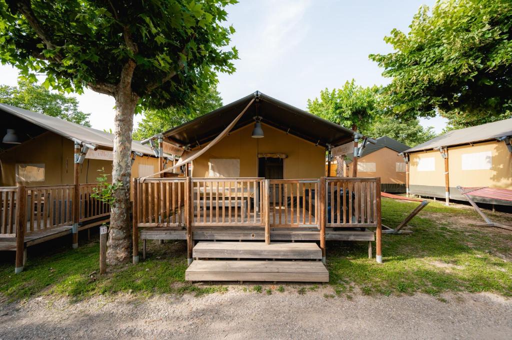 ein Haus mit einer Veranda und einem Baum in der Unterkunft Glamping Terme Čatež in Brežice