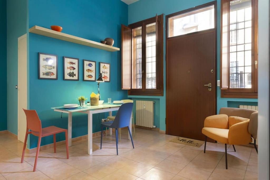 um quarto com uma mesa e cadeiras e uma parede azul em Blu Flat em Bolonha