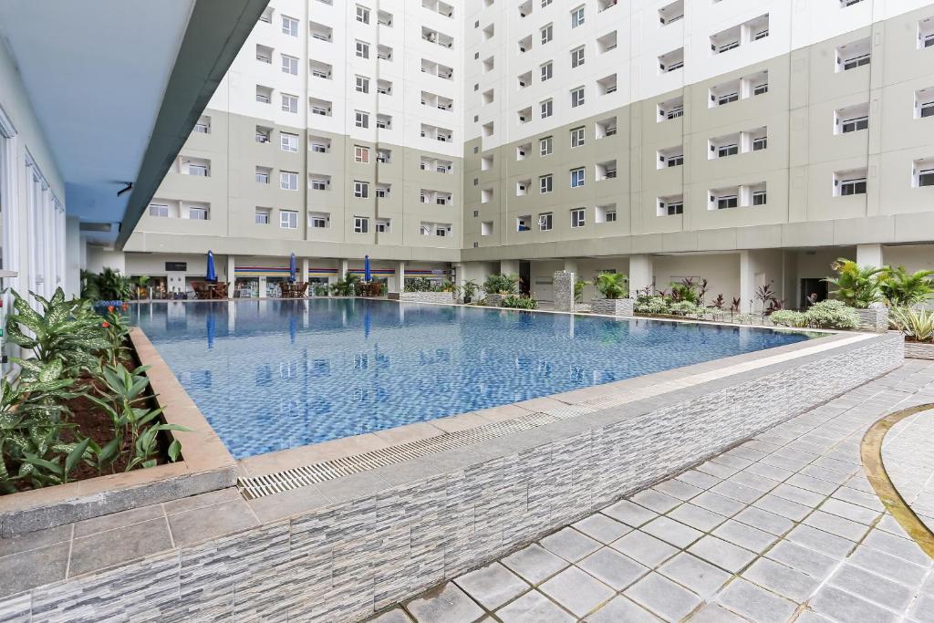 a swimming pool in front of a building at Capital O 93593 Pelangi Loftville City in Tangerang