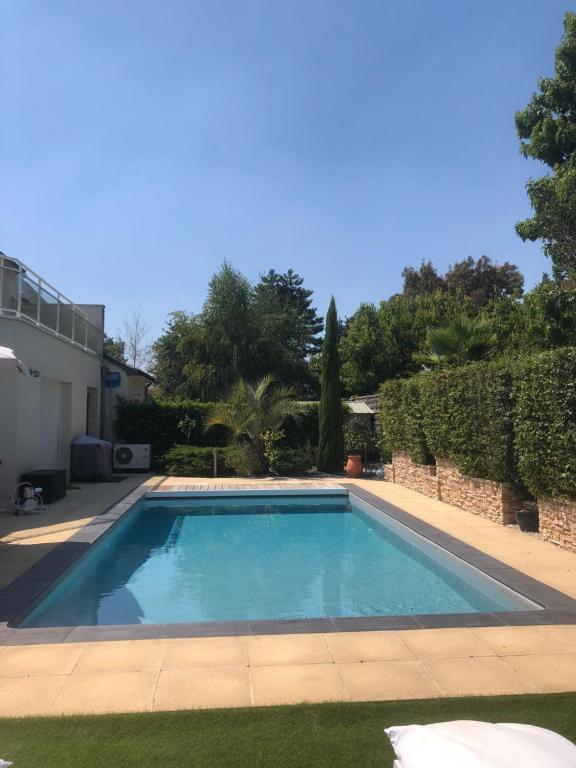 a swimming pool in a yard next to a house at Villa La Combe in Angers