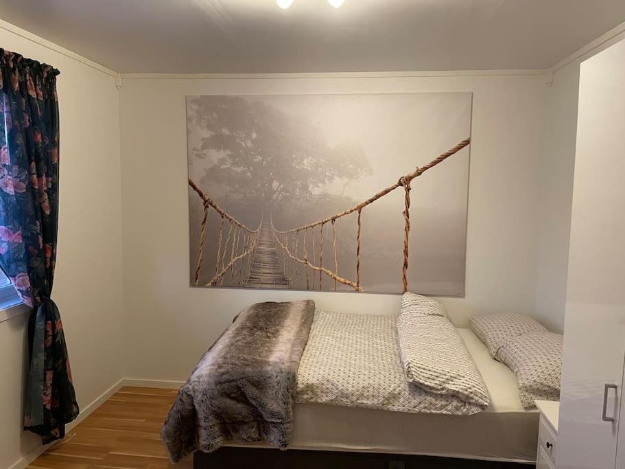 een bed in een kamer met een foto van een brug bij Leilighet ved porten til Senja. in Finnsnes